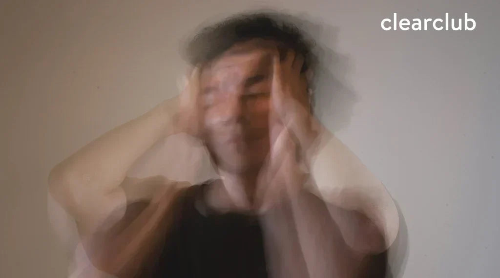 Man clutching head in pain from stress, sleep apnea, and teeth grinding
