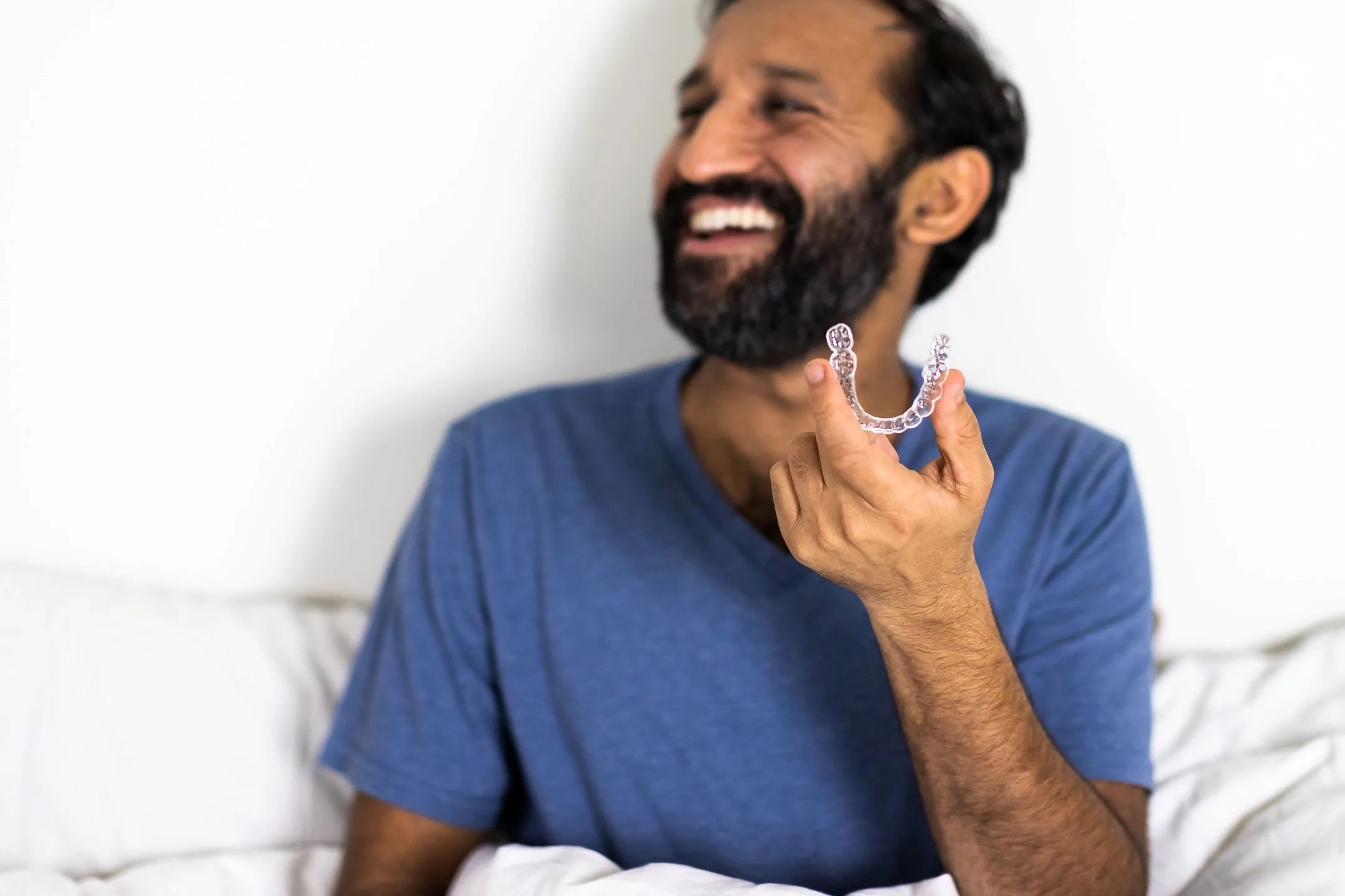 Man holding a custom dental mouth guard for sleeping