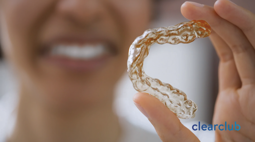 Yellowing mouthguard held by a woman reacting in disgust, indicating bacterial growth and mouthguard odor.