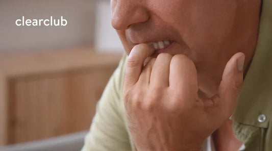 Man biting his fingernails, a common nail-biting habit that can affect oral health.