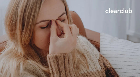 Woman pinching the area between her nose and forehead, representing sinusitis-related facial discomfort