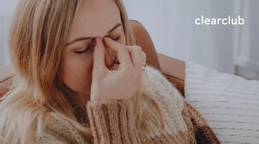 Woman pinching the area between her nose and forehead, representing sinusitis-related facial discomfort