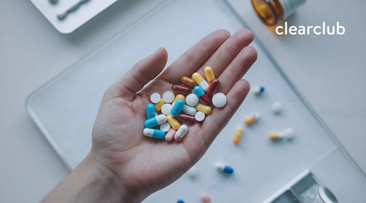 Hand holding several vitamin pills