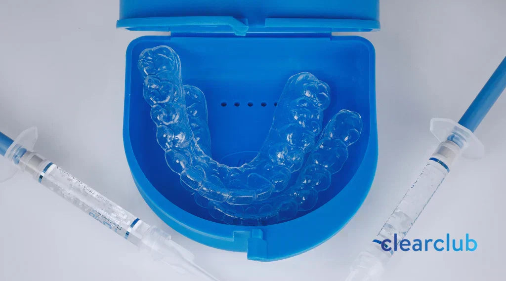 Two whitening trays placed on a blue plastic case, with whitening gels placed on each side.