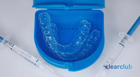 Two whitening trays placed on a blue plastic case, with whitening gels placed on each side.
