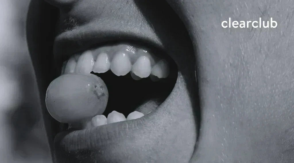 Flared teeth showing bite misalignment while biting a grape, affecting chewing and TMJ. 