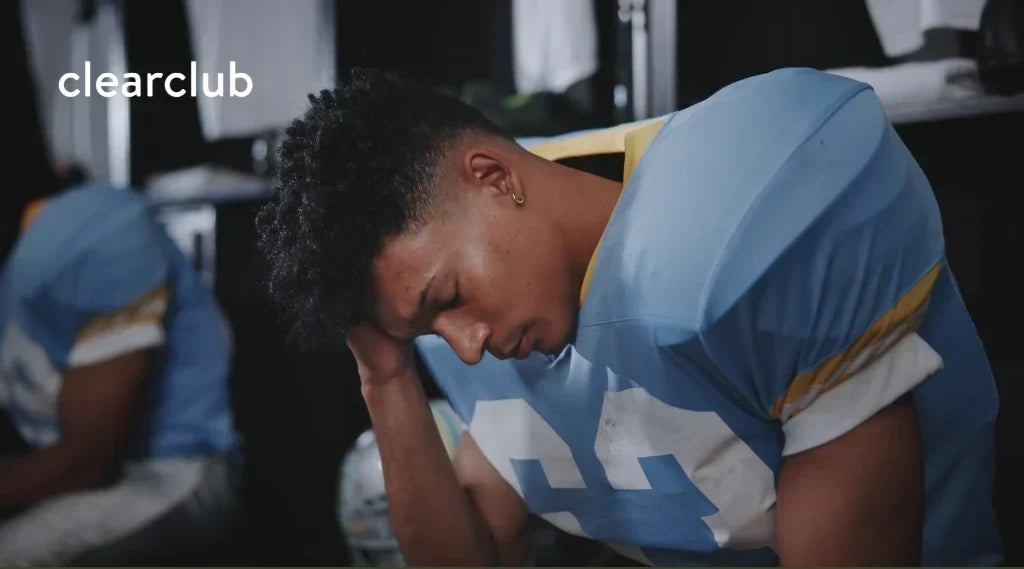 Football player holding his head after an impact during a game.