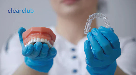 Dentist holding a clear night guard and a teeth model with a dental guard, demonstrating why dentists recommend night guards even without visible pain.