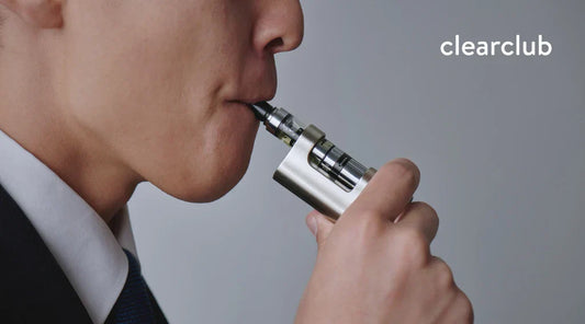 Man inhaling from a vape device, showing how vaping can cause tooth stains and discoloration — ClearClub Blog Visual