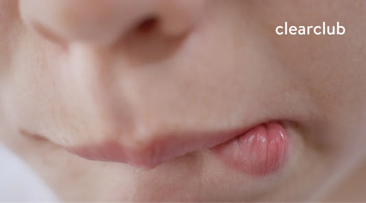 Person biting their lip, a habit linked to stress, bruxism, and other conditions.