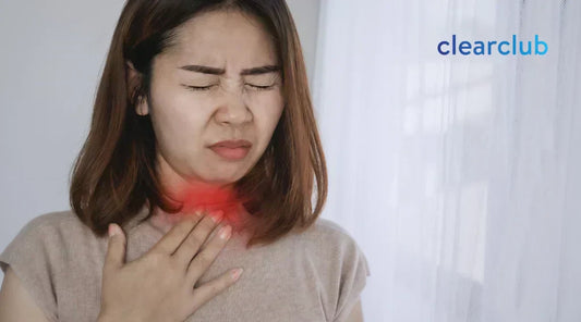 Woman with a scratchy, hoarse throat, a possible sign of a sore throat from wearing a night guard.