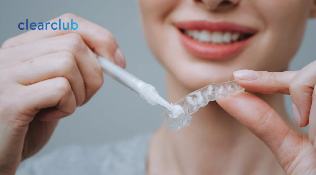 Woman filling whitening trays with gel, demonstrating at-home teeth whitening.