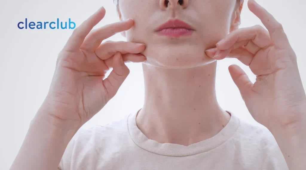Woman massaging her jaw to relieve tension from teeth grinding (bruxism).