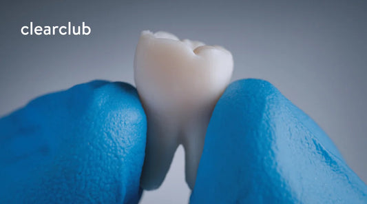 A dentist examining a tooth, illustrating potential damage caused by teeth grinding.