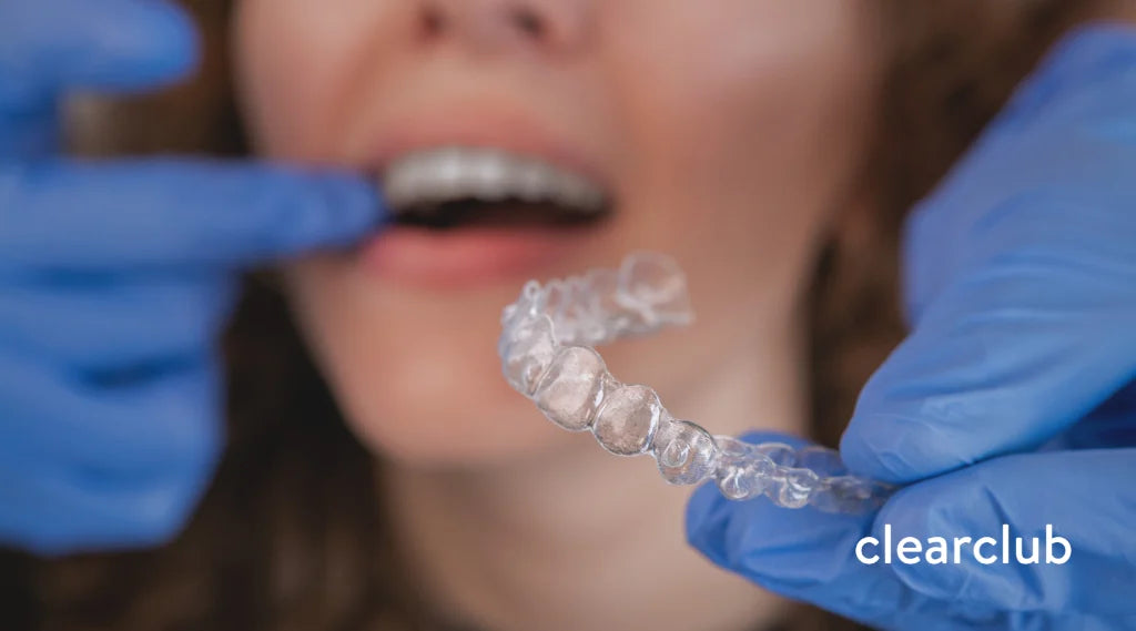 Dentist evaluating misaligned teeth caused by a retainer that no longer fits properly