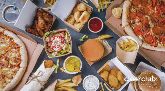 Top-down view of a table displaying foods and drinks that cause tooth stains, like coffee, sauces, and soda