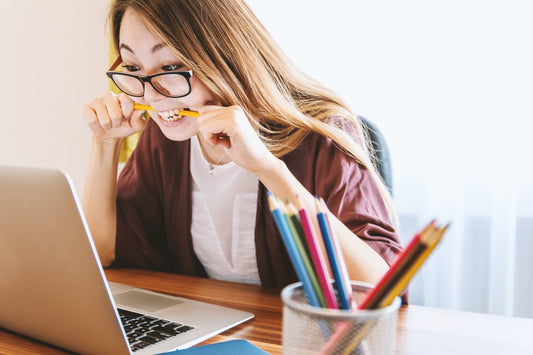 Woman clenching jaw in front of a computer