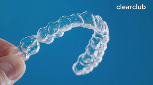 Person holding a clear plastic retainer in good condition, the standard for preventing teeth misalignment.